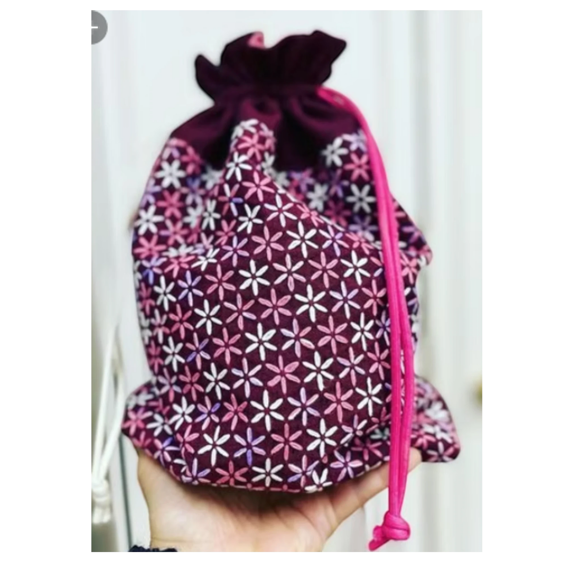 Daisy (Hinagiku) Bag Pattern, a plum drawstring pouch with a white, pink, and purple floral print and a bright pink cord.