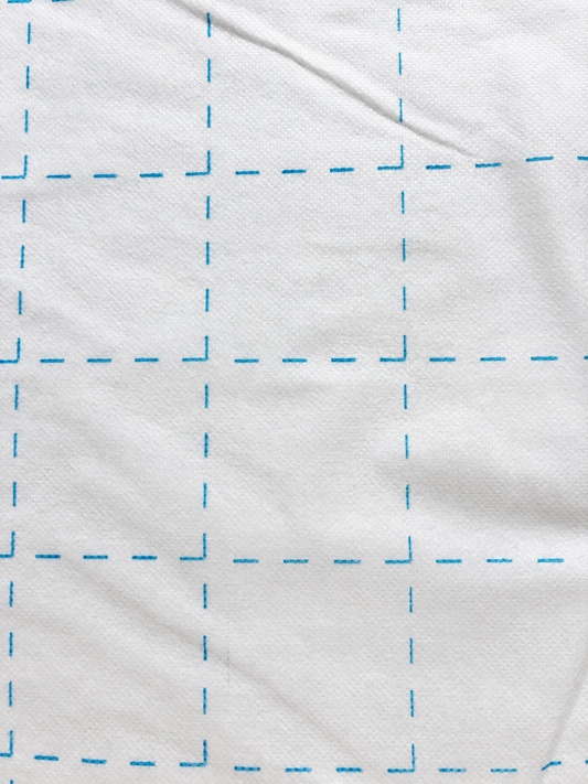 Bosal Quilter's Grid 2-inch fusible interfacing — single layer showing blue grid on white