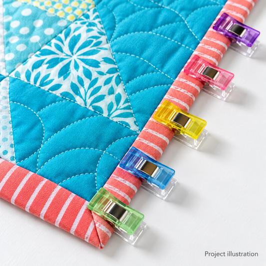 Project illustration for WCMP100: sewing clips holding quilt binding. Example project and materials are not included.