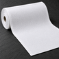 White huck fabric unrolling on a charcoal background, with a fine diamond weave, hemmed sides and a raw cut end